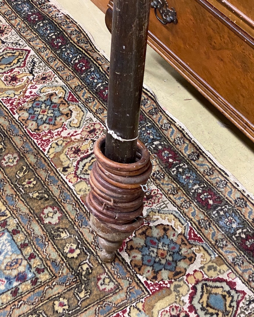 A Victorian curtain pole with assorted rings, length 181cms.
